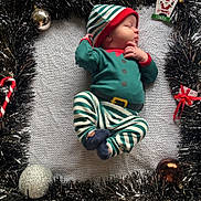Timéo participe au concours pour gagner de l'argent avec cette photo : baby, newborn, sleeping_baby, elf_outfit, striped_pajamas, christmas, tinsel, ornament, candy_cane, gift, knit_blanket, festive, holiday, hat, socks, closeup, portrait, cozy, cute, tiny