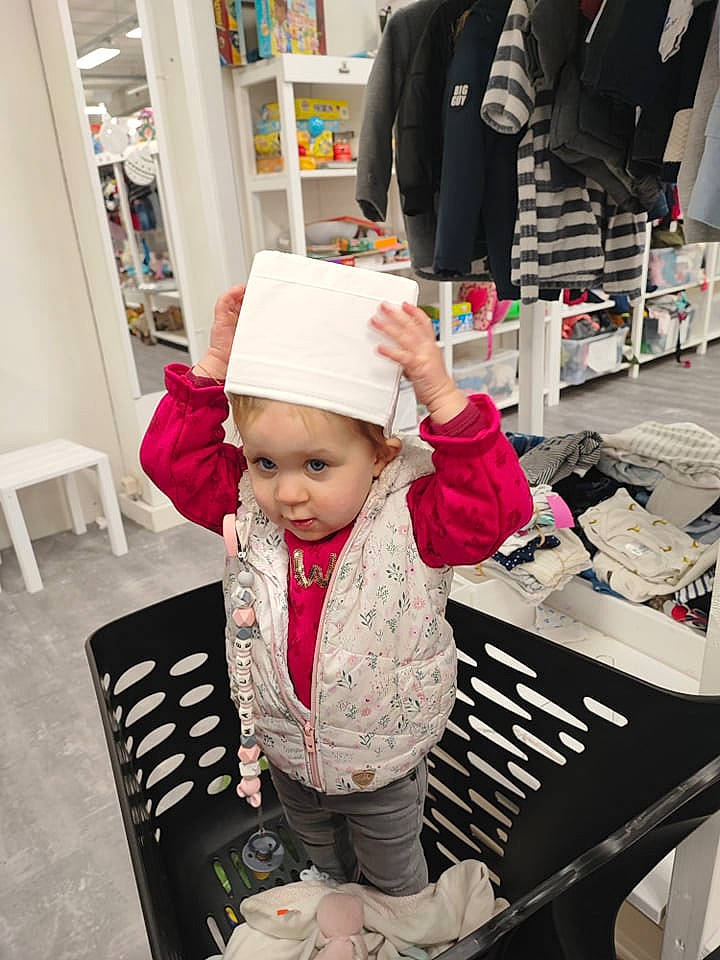 Maëlle participe au concours pour gagner de l'argent avec cette photo : baby, baby_toddler_clothing, bag, cap, chair, child, customer, fashion_accessory, headgear, headwear, luggage_and_bags, outerwear, person, retail, service, shelf, shopping, sitting, sleeve, smile