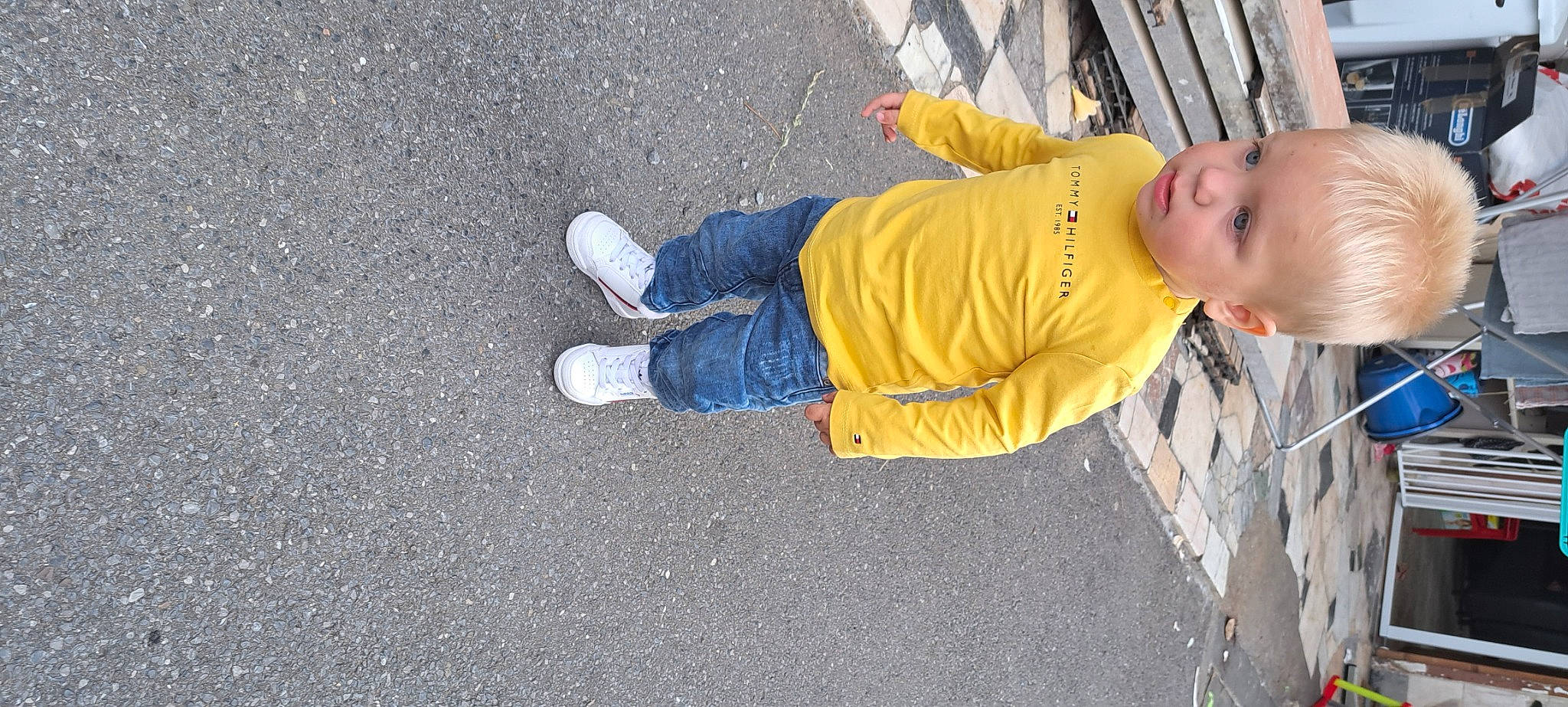 Sohan a rejoint le concours — aidez-le/la à gagner de superbes lots ! asphalt, baby, baby_toddler_clothing, child, concrete, denim, flooring, foot, fun, human_leg, outdoor_shoe, person, road_surface, shadow, sidewalk, sitting, smile, tar, toddler, walking_shoe