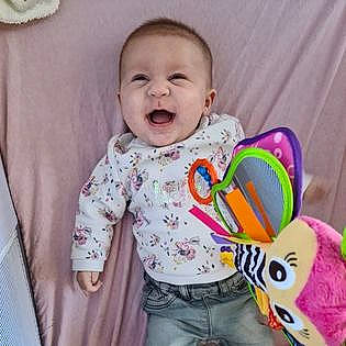 Maëlle participe au concours pour gagner de l'argent avec cette photo : baby, baby_laughing, baby_products, baby_toddler_clothing, baby_toys, bib, cheek, child, ear, head, neck, nose, person, pink, play, product, sleeve, smile, toddler