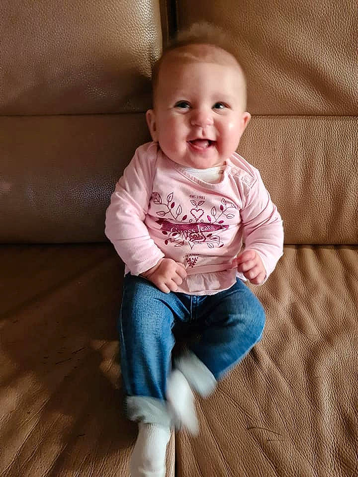 Maëlle participe au concours pour gagner de l'argent avec cette photo : baby, baby_toddler_clothing, cheek, child, head, person, sitting, skin, sleeve, smile, standing, toddler