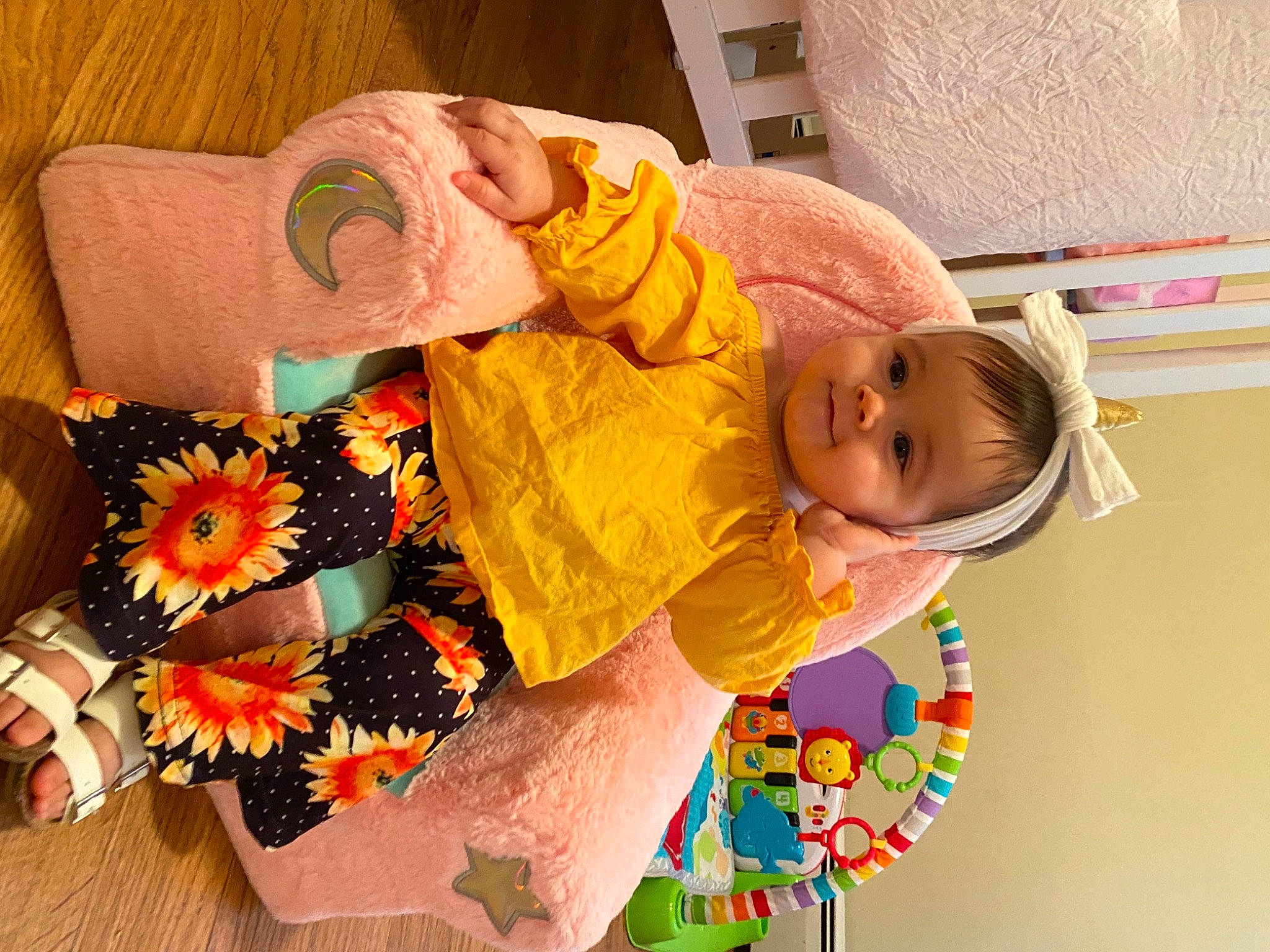 Avayah is registered to the contest to win money with this photo: art, baby, baby_products, baby_toddler_clothing, child, comfort, facial_expression, happy, linens, orange, pattern, person, petal, pink, plant, play, room, smile, toddler, wood