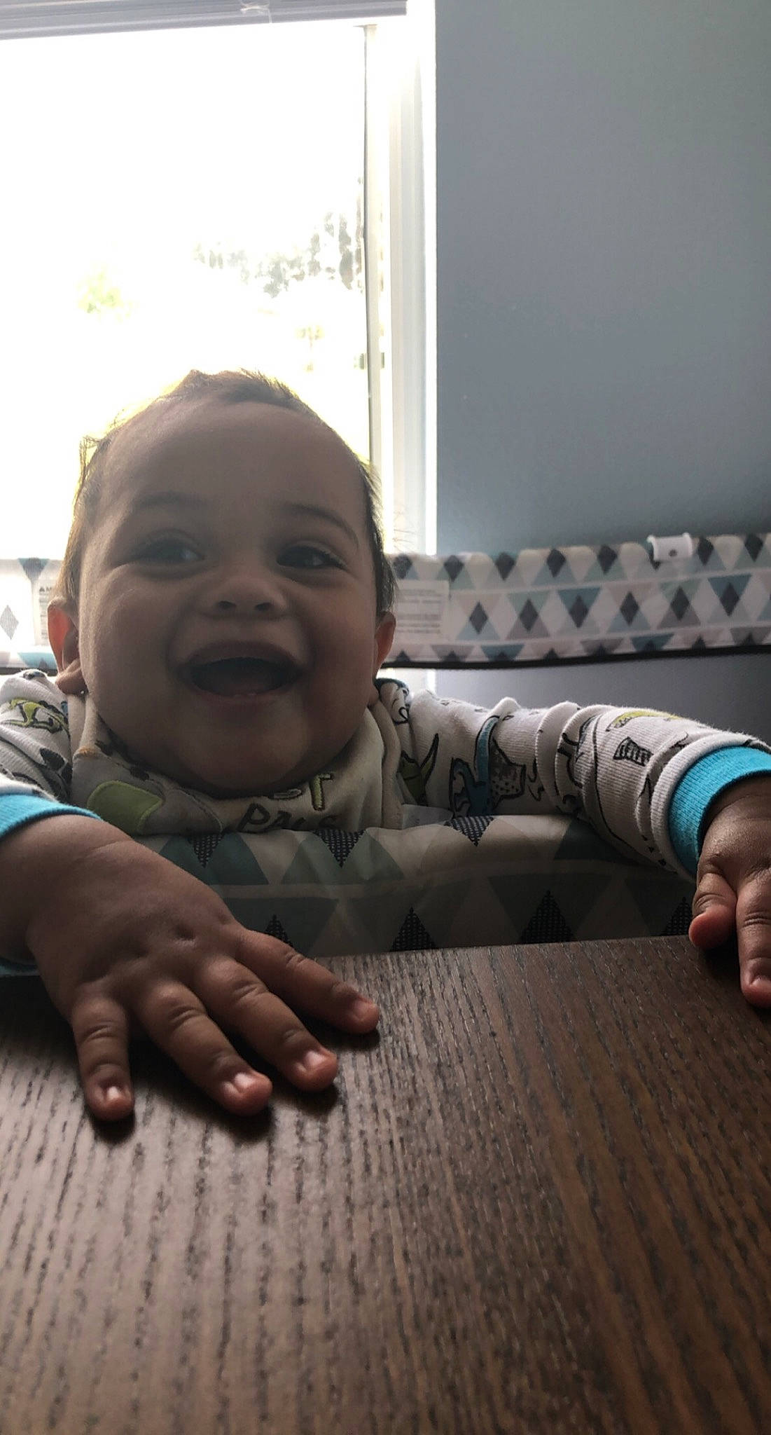 Aj is registered to the contest to win money with this photo: baby_toddler_clothing, cheek, child, comfort, finger, floor, flooring, gesture, happy, hardwood, nose, person, sitting, skin, smile, table, thumb, toddler, varnish, window