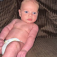 Waylon Blake joined the competition — help win amazing prizes! baby, diaper, couch, infant, skin, arm, leg, face, blue_eyes, expression, indoor, child, human, furniture, seated, curious, plush, texture, relaxed, young