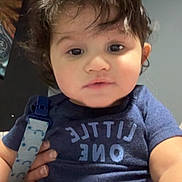 Jordan joined the competition — help win amazing prizes! baby, blue_clothing, child, close_up, clothing, curly_hair, cute, expression, face, hand, holding, indoor, infant, onesie, pacifier, person, portrait, seated, skin, young_child