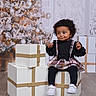 black_tights, child, christmas_tree, curly_hair, cute, decorations, dress, festive, flooring, gift_boxes, holiday_decor, holiday_season, indoor, sitting, smiling, toddler, white_shoes, winter, wrapped_presents, young_child