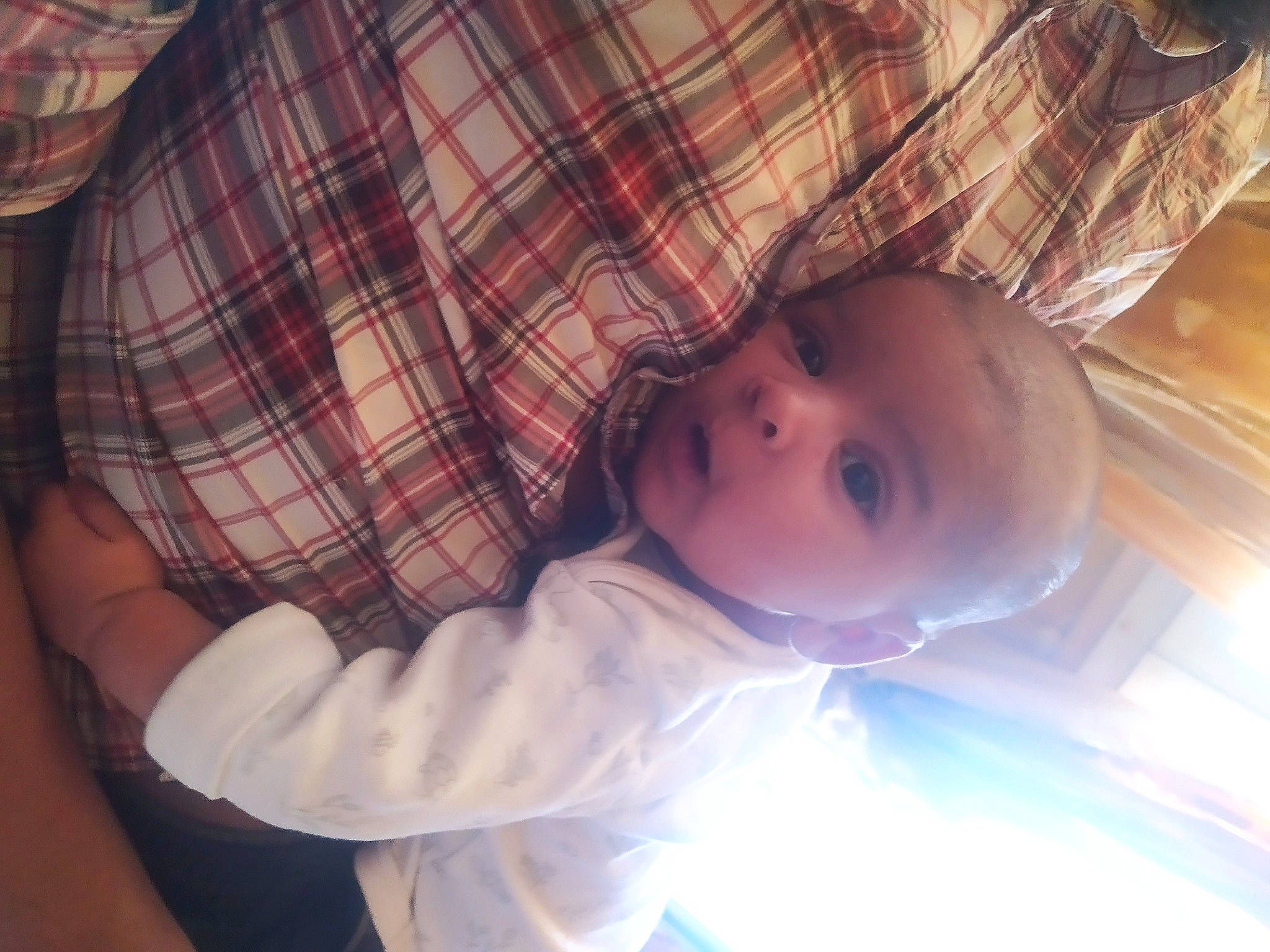 Kelyan participe au concours pour gagner de l'argent avec cette photo : baby, baby_toddler_clothing, cheek, child, comfort, finger, fun, happy, iris, mouth, nose, pattern, person, plaid, plant, sitting, skin, sleeve, tartan, toddler