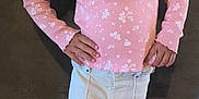 Siham participe au concours pour gagner de l'argent avec cette photo : child, girl, pink_shirt, floral_pattern, curly_hair, pigtails, cream_pants, pink_sneakers, standing, posing, hands_on_hips, smiling, indoor, concrete_floor, dark_wall, casual_clothing, portrait, fashion, young, cute