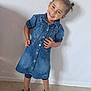Siham a rejoint le concours — aidez-le/la à gagner de superbes lots ! child, girl, denim_dress, smiling, standing, sandals, indoor, wall, floor, hair_buns, happy, casual_clothing, portrait, feet, young_child, person, fashion, cute, playful, pose