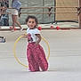 Siham a rejoint le concours — aidez-le/la à gagner de superbes lots ! child, girl, hula_hoop, gymnasium, mirrored_wall, red_ball, person, audience, sports_equipment, floor, casual_clothing, event, indoor, white_shirt, pink_pants, woman, barrier, crowd, motion_blur, activity