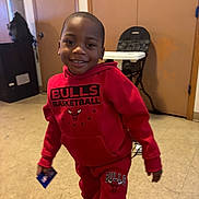 Jayceon joined the competition — help win amazing prizes! child, boy, smiling, indoors, red_clothing, hoodie, pants, sneakers, basketball, card, floor, door, high_chair, wall, person, casual, portrait, happy, playful, home