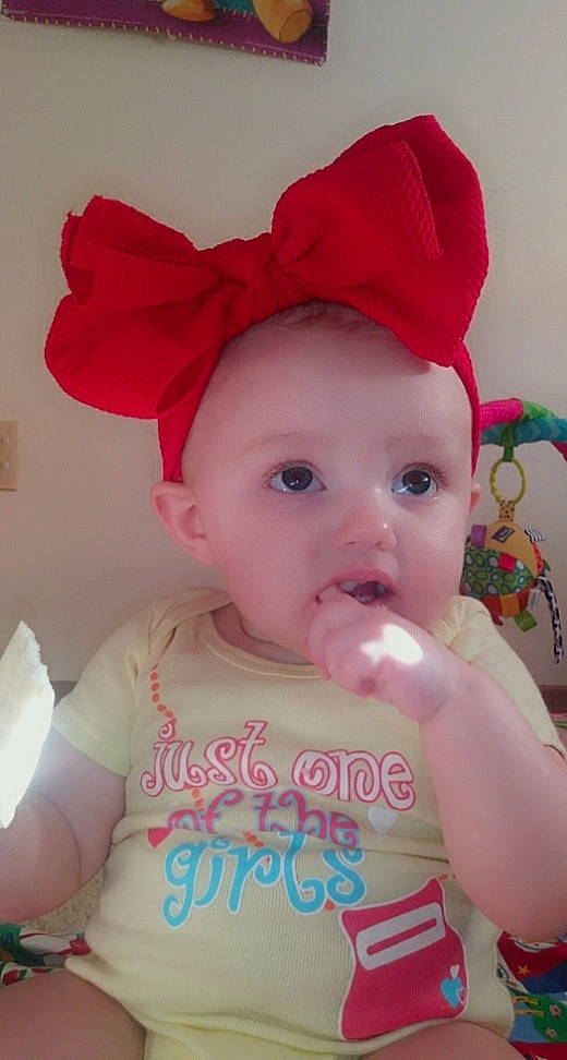 Emberlyn is registered to the contest to win money with this photo: baby, cheek, child, clothing, fashion_accessory, hair_accessory, headgear, lip, person, pink, surprise, toddler