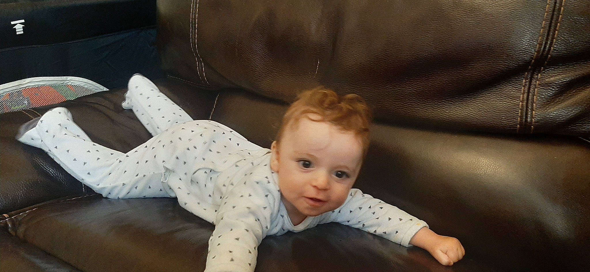 Thibault participe au concours pour gagner de l'argent avec cette photo : baby, baby_toddler_clothing, cheek, child, comfort, couch, crawling, elbow, flash_photography, flooring, fun, happy, head, nose, person, room, sitting, sleeve, smile, toddler