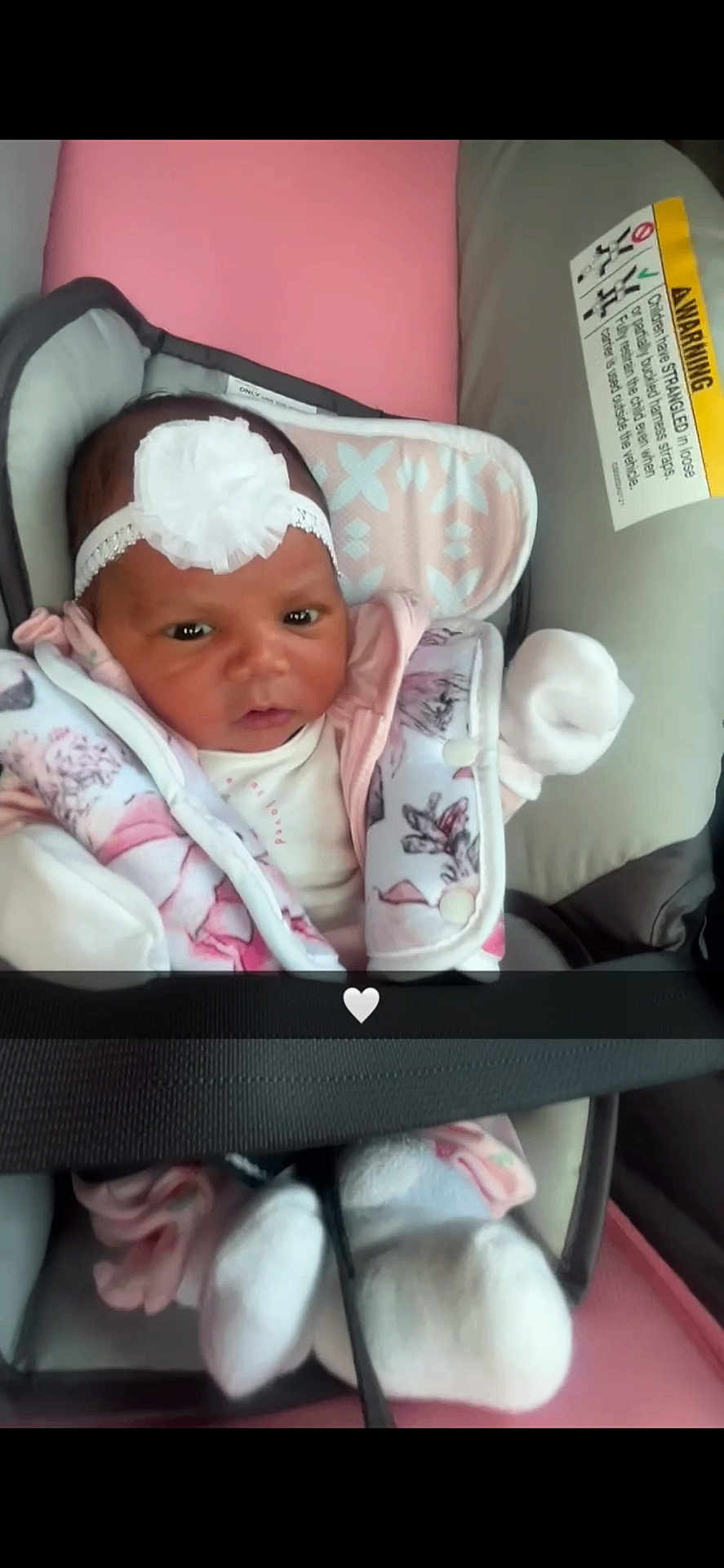 Namylah is registered to the contest to win money with this photo: baby, infant, car_seat, headband, white_flower, pink, jacket, mittens, safety_belt, cushion, warning_label, cute, child, indoor, portrait, clothing, seat, newborn, person, closeup