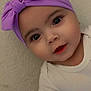 Tylia a rejoint le concours — aidez-le/la à gagner de superbes lots ! baby, child, headband, purple, bow, face, eyes, smile, onesie, white_clothing, infant, portrait, closeup, cute, young_child, indoor, wall, skin, person, expression
