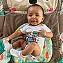 baby, infant, child, onesie, play_mat, smiling, happy, cute, sock, floor, colorful, animal_design, indoor, toddler, clothing, diaper, person, young_child, cute_face, sitting