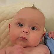 Knox is registered to the contest to win money with this photo: baby, infant, close_up, face, blue_blanket, skin, hand, eyes, expression, curious, tuft_of_hair, indoors, soft_light, portrait, young_child, child, person, cute, newborn, resting