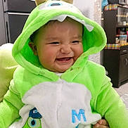 Christian joined the competition — help win amazing prizes! baby, child, costume, green, monster, smiling, indoor, kitchen, fridge, decoration, snowman, hood, cute, happy, apparel, person, screenshot, social_media, caption, home