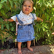 Syana participe au concours pour gagner de l'argent avec cette photo : toddler, child, denim, dress, white_shirt, barefoot, garden, plants, greenery, wooden_surface, funny_face, cute, outdoors, sunlight, standing, bracelet, pacifier_clip, nature, small_person, happy