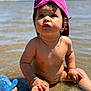 toddler, child, beach, water, sunlight, pink_cap, bracelet, sand, barefoot, shallow_water, summer, outdoor, cute, wet_skin, playing, sunny, portrait, blue_sky, young_child, daytime