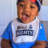 Sevyn joined the competition — help win amazing prizes! toddler, baby, child, head_wrap, blue_shirt, bib, indoor, happy, open_mouth, hands, expression, portrait, face, skin, clothing, lamp, door, cute, smiling, person