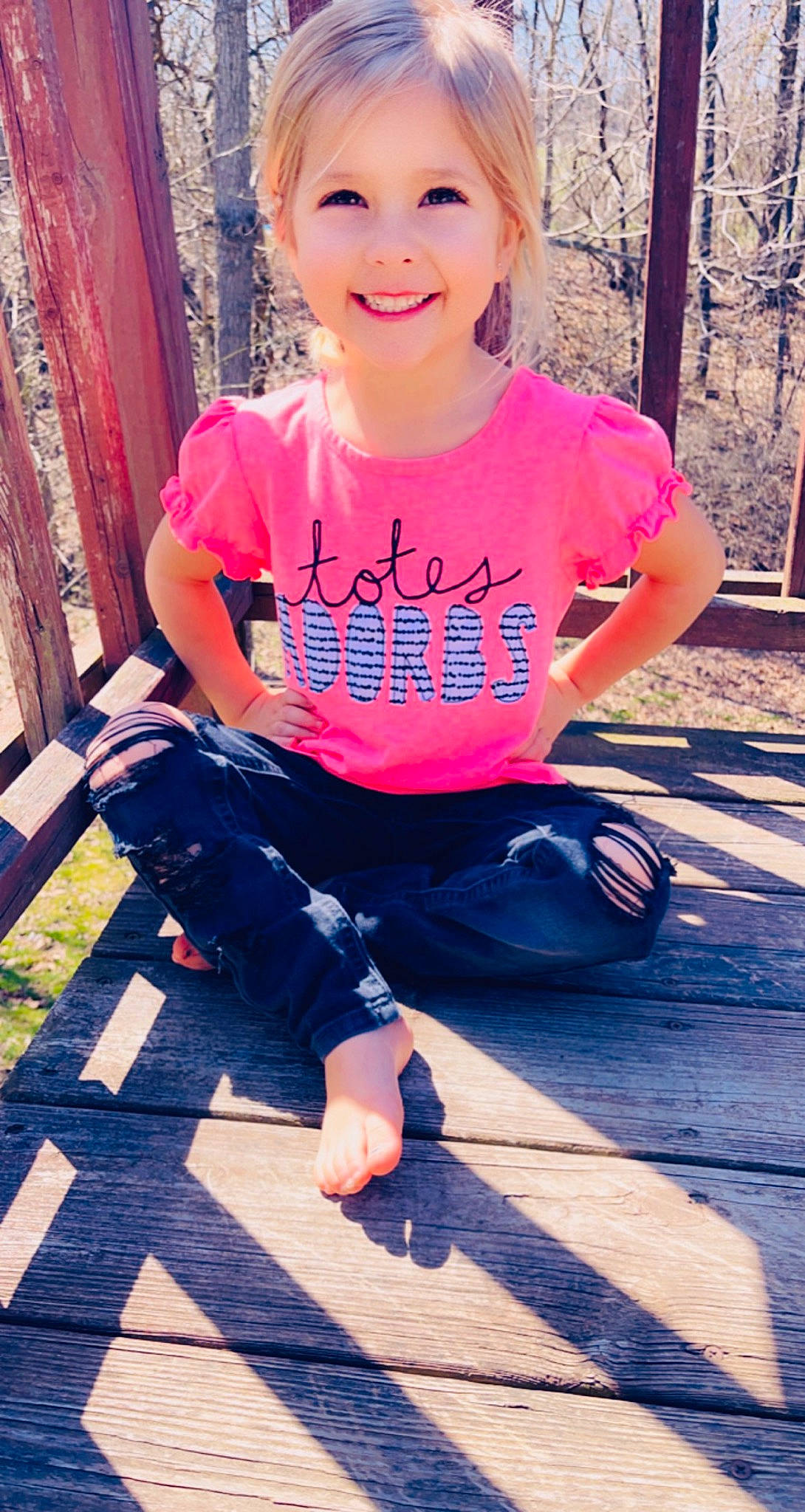 Kynli is registered to the contest to win money with this photo: clothing, cool, face, facial_expression, fashion, happy, jeans, joy, leg, person, photograph, pink, plant, shoe, sleeve, smile, standing, street_fashion, sunlight, t_shirt