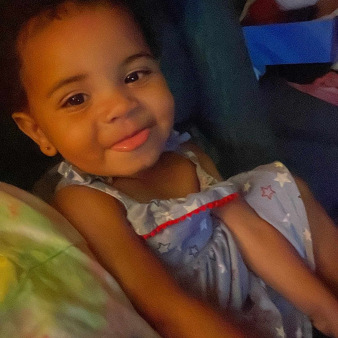 Zilyssa joined the competition — help win amazing prizes! blanket, child, colorful, cozy, cute, dress, eyebrows, face, furniture, hair, happy, indoors, person, seated, skin, smiling, star_pattern, toddler, tongue_out, young_child