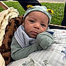 Princeton is registered to the contest to win money with this photo: baby, infant, hat, blanket, greenery, outdoor, cute, face, clothing, pattern, cozy, portrait, young_child, nature, expression, lying_down, headwear, soft_texture, baby_boy, resting