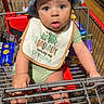 baby, shopping_cart, hat, bib, grocery_store, child, infant, curious, retail, aisle, floor, green_clothing, red, metal_cart, drool, seat, person, cute, wide_eyes, shopping