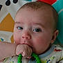 Mason is registered to the contest to win money with this photo: baby, infant, teething_ring, hand, face, eyes, clothing, colorful_background, musical_notes, cute, closeup, skin, expression, child, young, portrait, soft_lighting, indoors, playful, toy