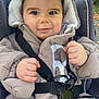 Lúca participe au concours pour gagner de l'argent avec cette photo : baby, bundle, child, coat, curious, cute, face, hands, hood, infant, nature, outdoor, park, portrait, seatbelt, smile, straps, stroller, walk, winter_clothing