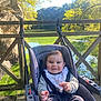 Lúca a rejoint le concours — aidez-le/la à gagner de superbes lots ! baby, child, daylight, greenery, happy, infant, nature, outdoor, park, pond, relaxation, rock, scenery, seatbelt, smiling, stroller, sunlight, trees, water, wooden_bridge