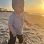 toddler, child, beach, sand, sunset, toy, barefoot, ocean, water, sunlight, outdoor, shore, waves, playing, clothing, sky, nature, portrait, casual, daylight
