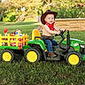 Diago León is registered to the contest to win money with this photo: baby, boots, child, cowboy_hat, denim, farm, garden, grass, john_deere, outdoor, portrait, red_bandana, sitting, smiling, steering_wheel, sunlight, toy_tractor, toy_wagon, toys, tractor