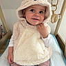 baby, changing_pad, child, curious, cute, face, hoodie, indoors, long_sleeve_shirt, nursery, pink_pants, playful, plush_clothing, portrait, sitting, smile, soft_texture, toddler, toy, wooden_frame