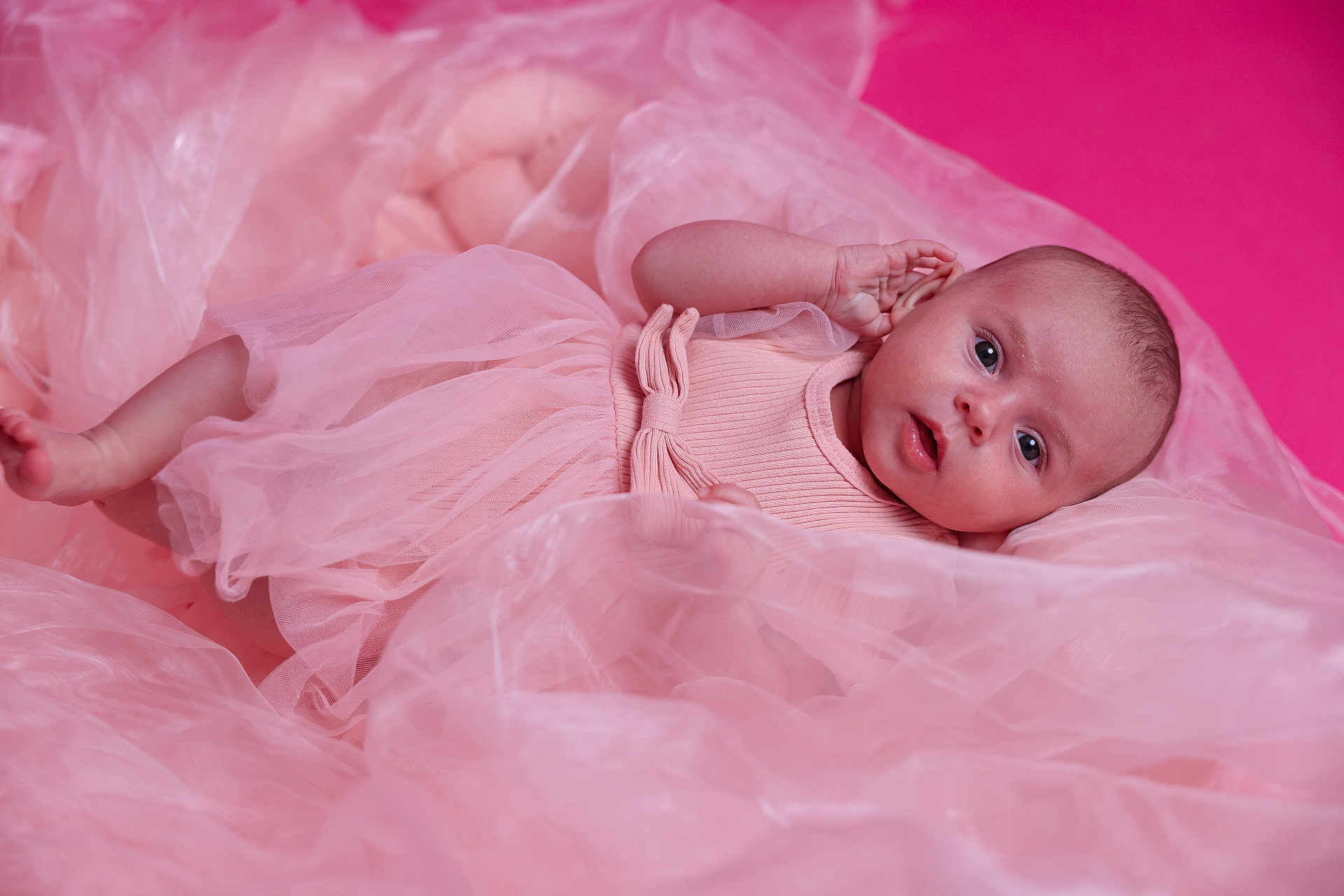 Julia a rejoint le concours — aidez-le/la à gagner de superbes lots ! baby, infant, pink_dress, fabric, soft, portrait, cute, child, lying_down, curious, face, skin, small_hand, newborn, studio, photography, tulle, background, closeup, adorable