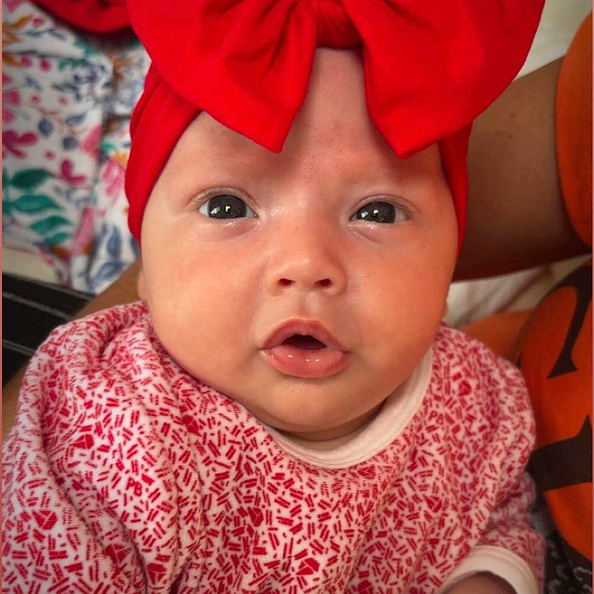 Rubby a rejoint le concours — aidez-le/la à gagner de superbes lots ! adorable, baby, child, closeup, clothing, curious, cute, expression, face, hand, headband, indoor, infant, newborn, patterned_outfit, person, portrait, red_bow, skin, young