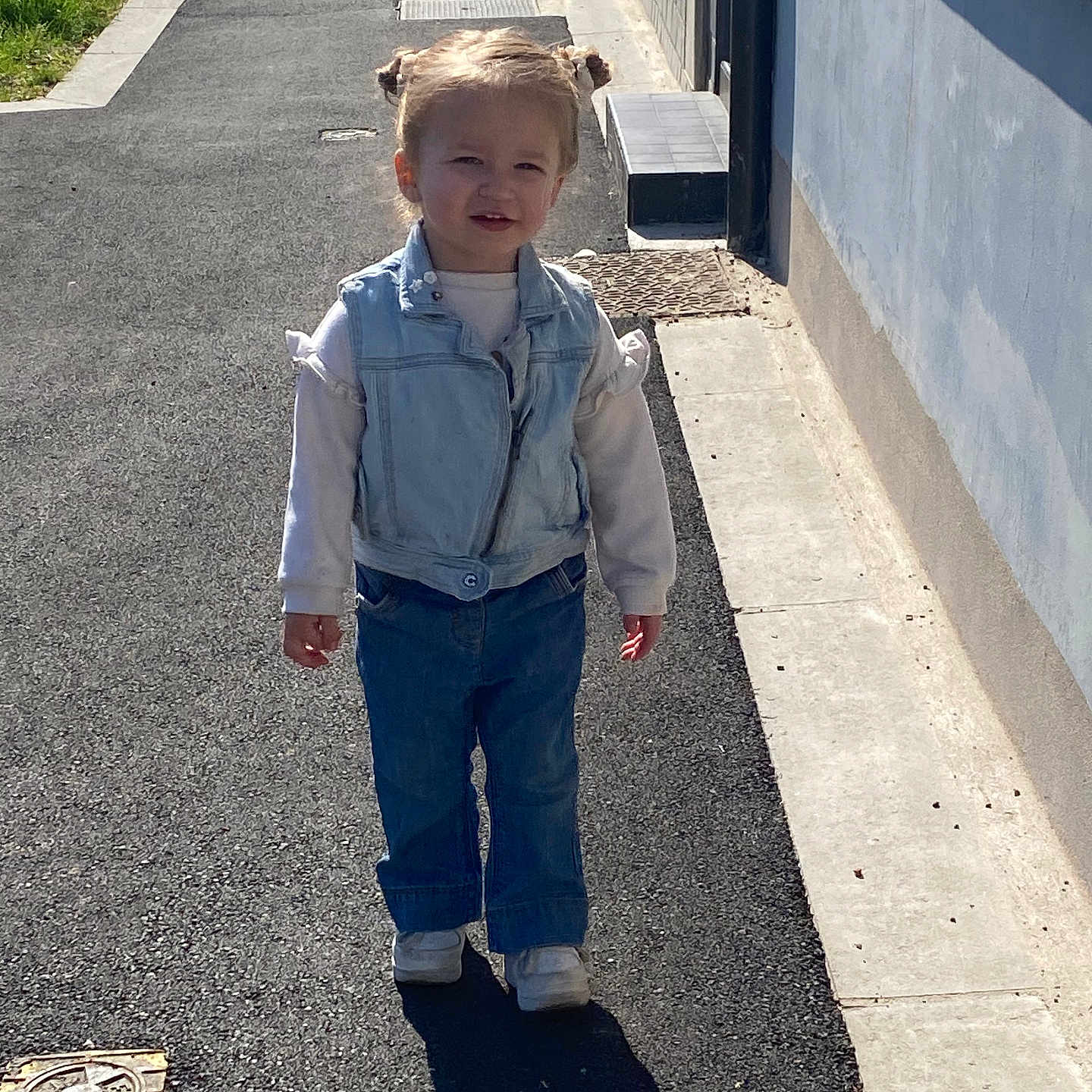 Lyahna a rejoint le concours — aidez-le/la à gagner de superbes lots ! casual_clothing, child, cute, daylight, denim_vest, hair_buns, happy, jeans, outdoor, pavement, person, shadow, sidewalk, small_child, smiling, sunny, toddler, urban, walking, white_sneakers