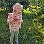 child, girl, apple, apple_orchard, outdoor, grass, tree, nature, daylight, happy, smiling, holding, fruit, greenery, footwear, clothing, long_sleeve, pants, shoes, sunlight