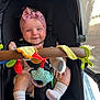 Manaia joined the competition — help win amazing prizes! baby, child, stroller, pink_bow, headband, smile, socks, toy, colorful_toy, infant, happy, seated, indoors, black_stroller, clothing, cute, playful, hands, feet, comfort