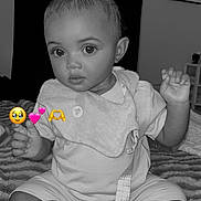 Jamya is registered to the contest to win money with this photo: baby, child, infant, black_and_white, sitting, bib, pacifier, hair_clip, blanket, indoor, cute, face, hands, feet, expression, young_child, portrait, person, emojis, decor