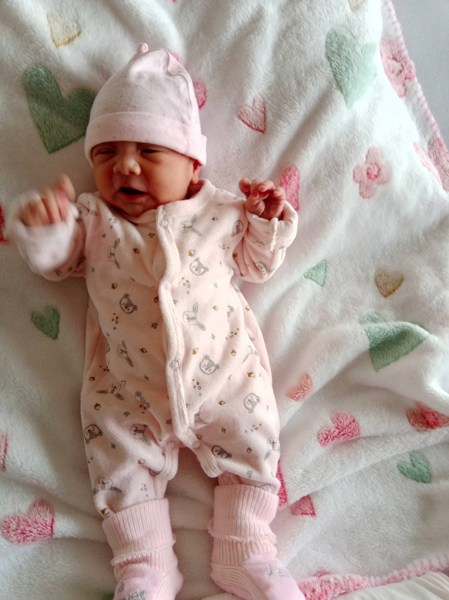 Tiarã a rejoint le concours — aidez-le/la à gagner de superbes lots ! arm, baby, baby_safety, baby_sleeping, baby_toddler_clothing, child, collar, comfort, face, hand, headwear, linens, outerwear, pattern, person, pink, product, skin, sleeve, textile