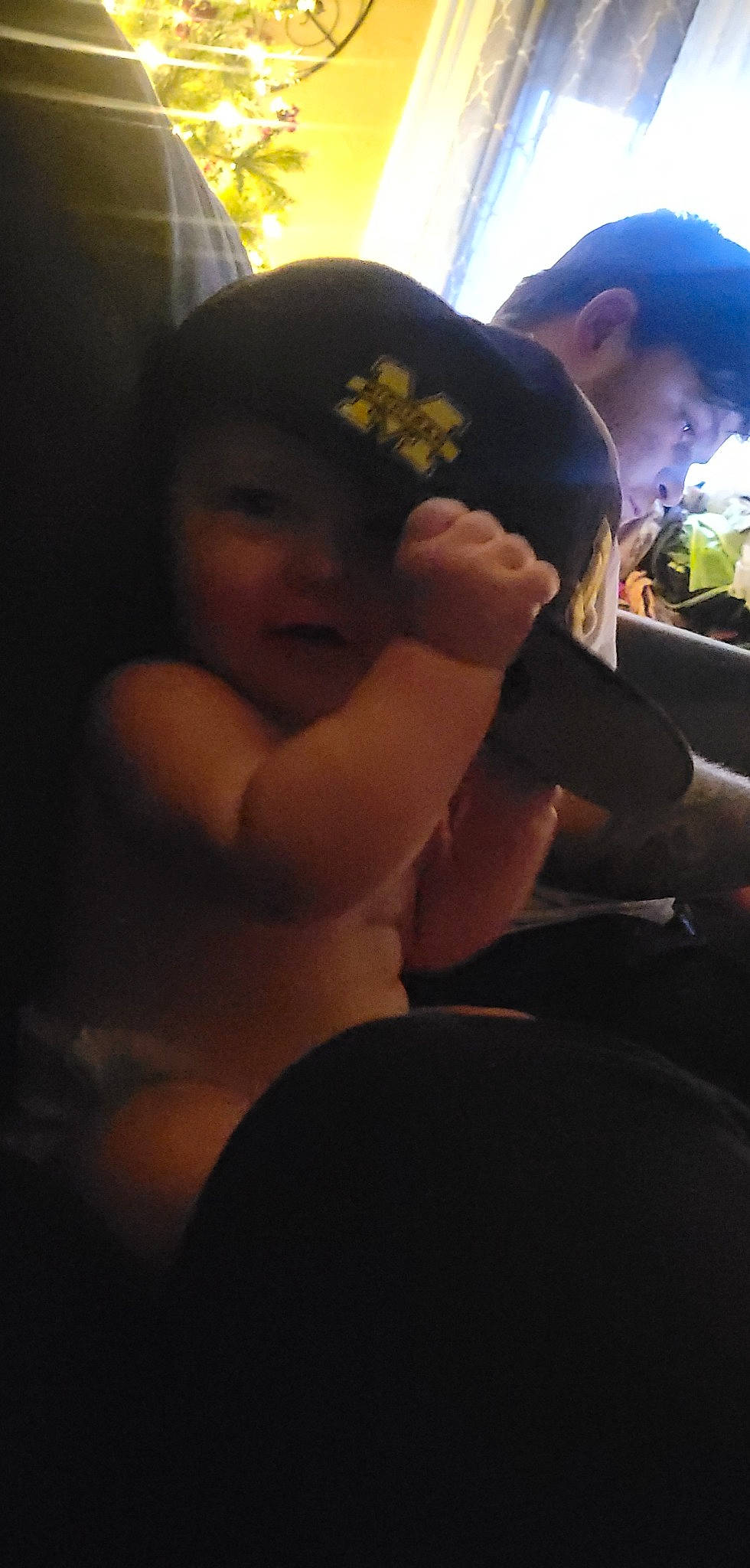 Makenzie is registered to the contest to win money with this photo: abdomen, black_hair, cap, cloud, darkness, elbow, flash_photography, fun, happy, hat, headgear, helmet, human_leg, mouth, person, plant, sitting, thigh, tints_and_shades, toddler