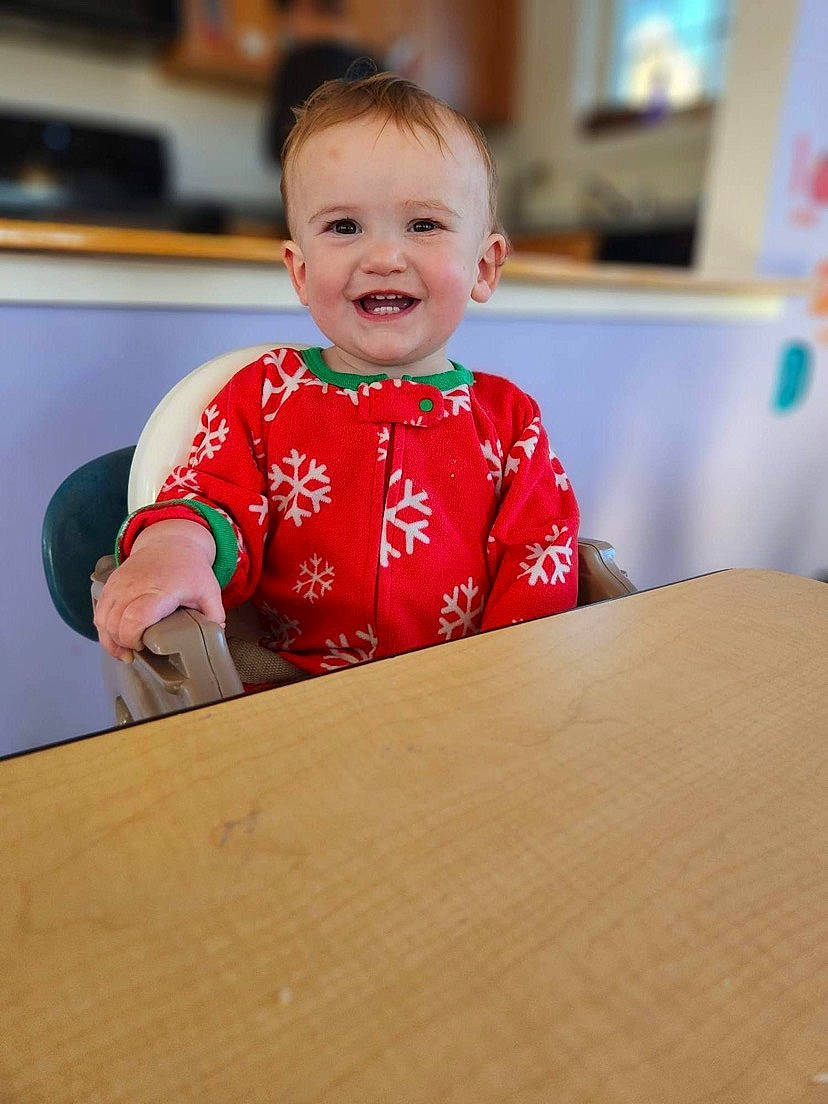Cali is registered to the contest to win money with this photo: baby, baby_toddler_clothing, child, event, flooring, fun, happy, hardwood, joy, leisure, person, recreation, room, sitting, sleeve, smile, t_shirt, table, toddler, varnish