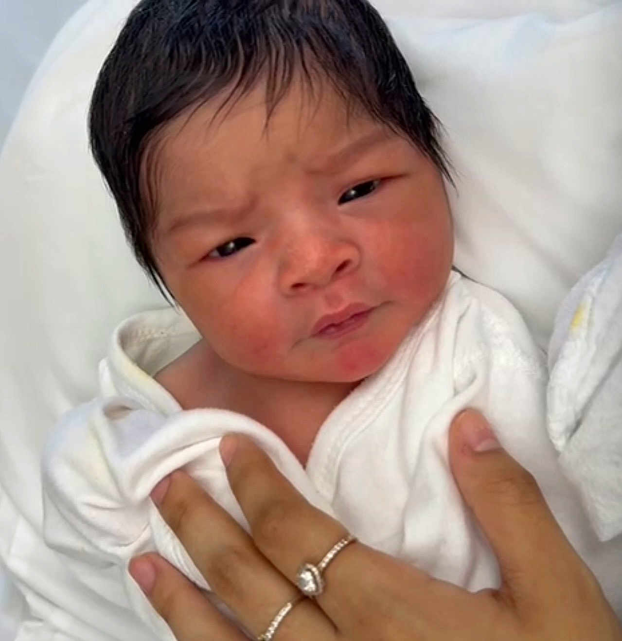 Aslan joined the competition — help win amazing prizes! newborn, baby, infant, portrait, face, hair, hand, white_clothing, blanket, skin, expression, curious, intense, closeup, person, human, gentle_touch, soft, indoors, newborn_baby