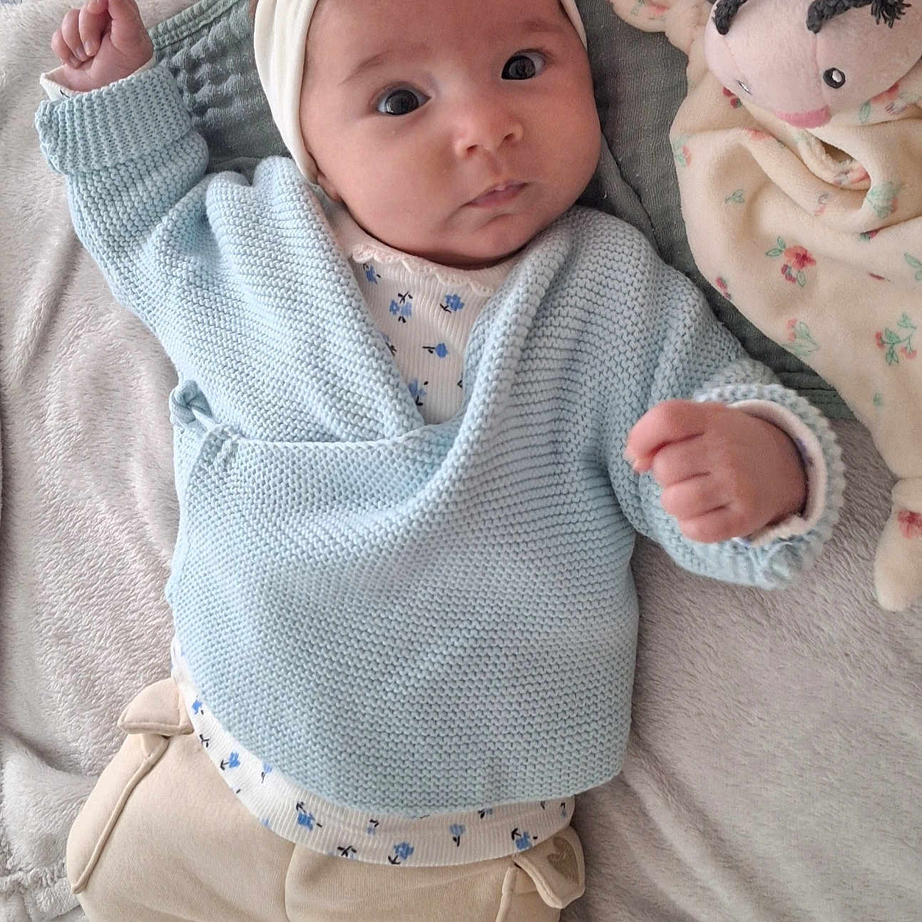Valentina participe au concours pour gagner de l'argent avec cette photo : baby, infant, blue_sweater, headband, bow, plush_toy, blanket, fist, cute, lying_down, soft_texture, indoors, clothing, face, person, expression, comfort, child, toy, sleepwear
