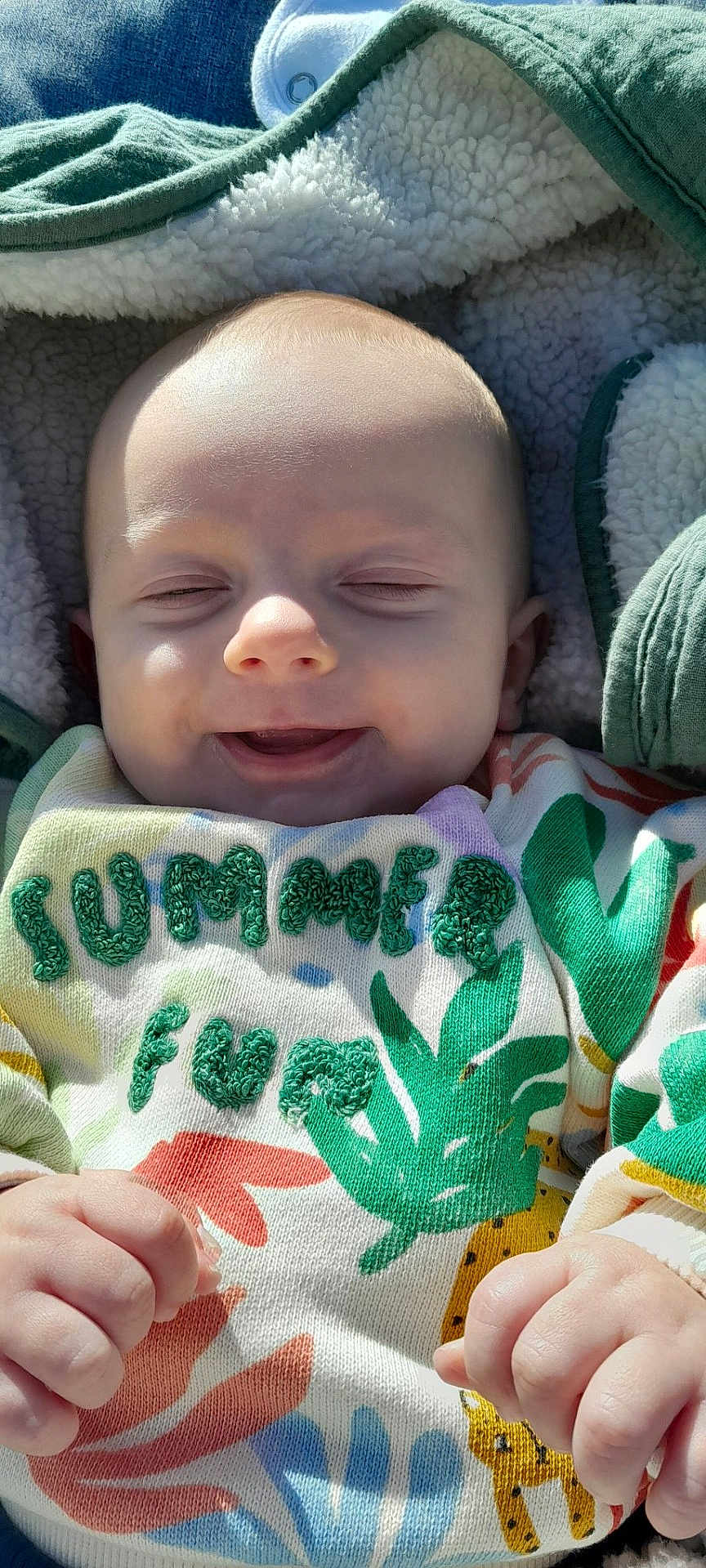 Marius a rejoint le concours — aidez-le/la à gagner de superbes lots ! baby, infant, smiling, blanket, sweater, colorful_clothing, embroidery, green, white, soft_texture, cute, happy, hands, outdoor_light, face, head, child, cozy, pattern, nature_theme