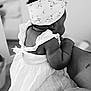 baby, child, black_and_white, dress, headband, arm, adult, holding, curly_hair, back_view, innocence, soft_focus, portrait, cute, toddler, human, skin, clothing, person, indoor