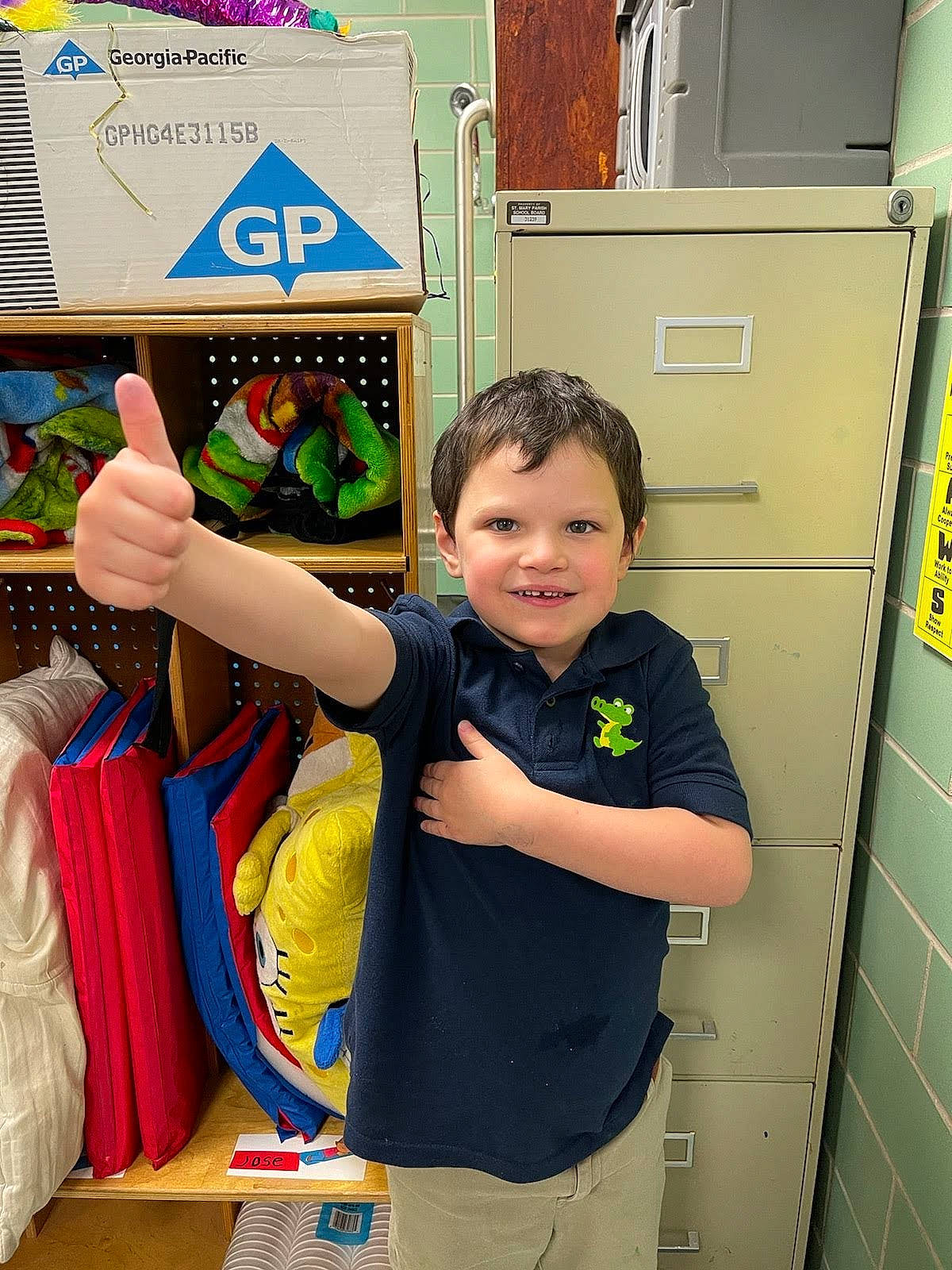 Saegan is registered to the contest to win money with this photo: box, cabinetry, child, drawer, event, flooring, fun, happy, joy, leisure, locker, person, play, product, recreation, room, shorts, smile, standing, t_shirt