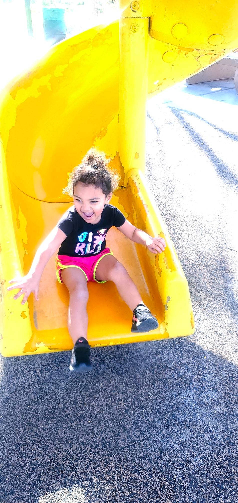 Aaliyah is registered to the contest to win money with this photo: asphalt, child, chute, city, electric_blue, fun, grass, happy, human_leg, joy, leisure, outdoor_play_equipment, person, playground, playground_slide, recreation, shorts, smile, t_shirt, thigh